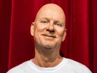 Rüdiger Hoffmann vor rotem Samtvorhang