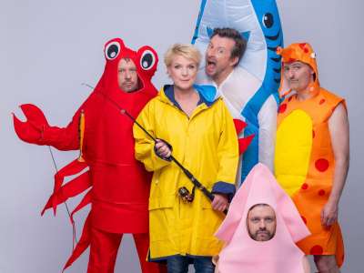 Mirja Boes steht im gleben Regenmantel mit einer Angel in ihren Händen im Zentrum des Bilds. Um sie herum stehen die Mitglieder ihrer Band (Die HoneyDonkeys) in Kostümen als Hai, Krabbe, Kalmar und Fisch verkleidet.